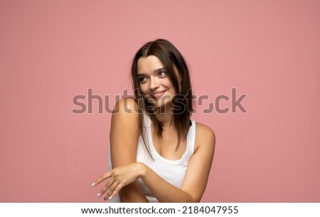 Funny cute young girl smiling winking at camera over pink background.
