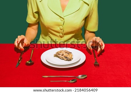 Food pop art photography. Cropped image of woman eating oyster on red tablecloth isolated over green background. French style. Vintage, retro style. Complementary colors, Copy space for ad, text Royalty-Free Stock Photo #2184056409
