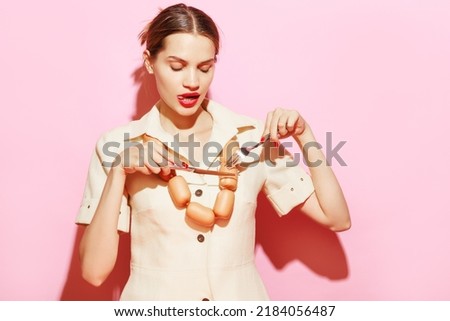 Image of woman eating necklace made from sausages. Creative food advertisement. Delicious. Food pop art photography. Vintage, retro style. Complementary colors, Copy space for ad, text