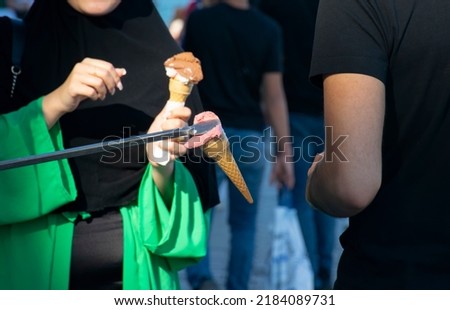 Turkish ice cream vendor jokes and customers having fun. Traditional turkish ice cream sales. Royalty-Free Stock Photo #2184089731
