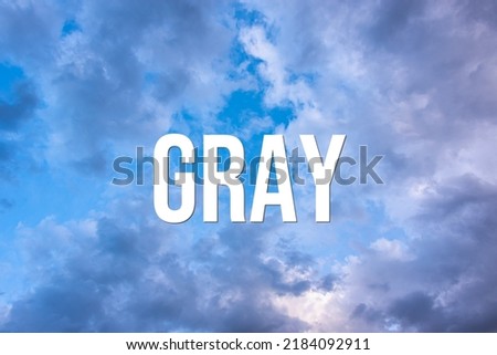 GRAY - word on the background of the sky with clouds.
