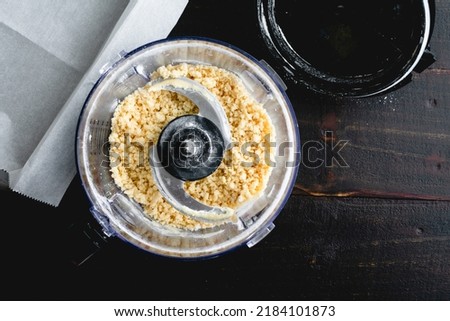Making Buttery Pastry Crust in a Food Processor: Overhead view of flour, butter, and sugar mixed in a food processor Royalty-Free Stock Photo #2184101873