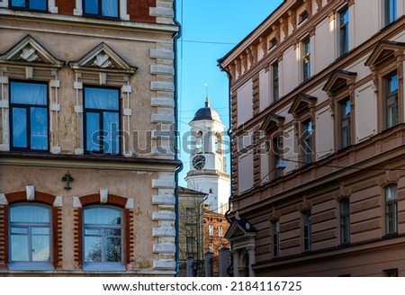 old streets of the historic city. house windows. Clock tower in Vyborg, former bell tower of the Old Cathedral Royalty-Free Stock Photo #2184116725