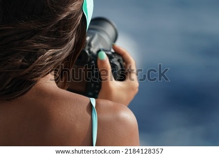 woman taking pictures at the sea with camera