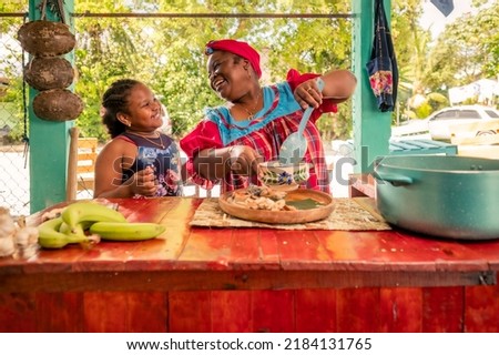 African American mother and daughter or grandmother and granddaughter enjoy the moment of being together in the kitchen. Happy family in the kitchen. Royalty-Free Stock Photo #2184131765