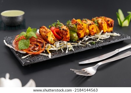 Paneer Tikka is popular Indian appetizer made with cubes of paneer and veggies marinated with yogurt and spices Royalty-Free Stock Photo #2184144563