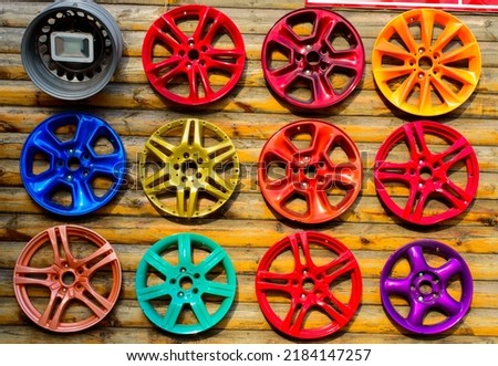 Set of a colorful wheel caps on the wooden wall. Ukraine, Odessa - car service. Background picture.