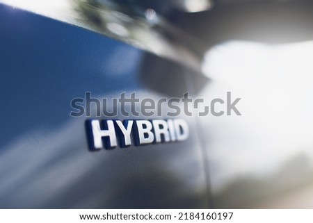 Close-up of Hybrid icon on car body. Environment concept.