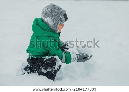Baby playing in the snow. snow games in the fresh air. Baby fun. Baby's game. sculpting a snowman.