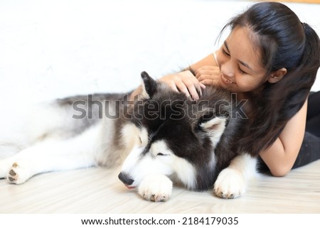 Beautiful asian woman posing with lovely friendly siberian husky dog.