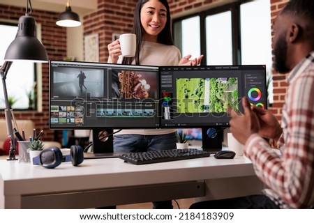 Diverse freelancers editing film footage on computer, using movie making software with visual and sound effects. Working on post production montage to make creative content on app.