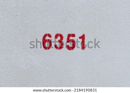 Red Number 6351 on the white wall. Spray paint.
