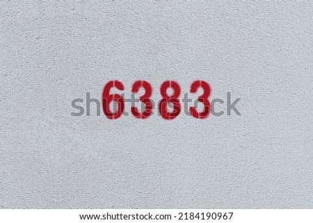 Red Number 6383 on the white wall. Spray paint.
