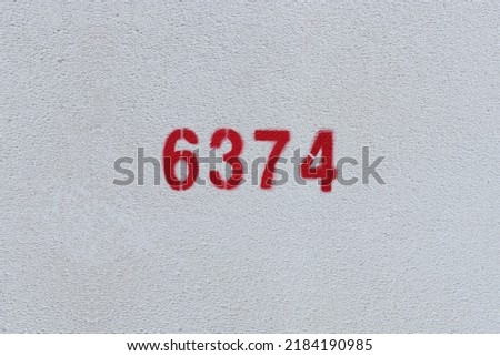 Red Number 6374 on the white wall. Spray paint.
