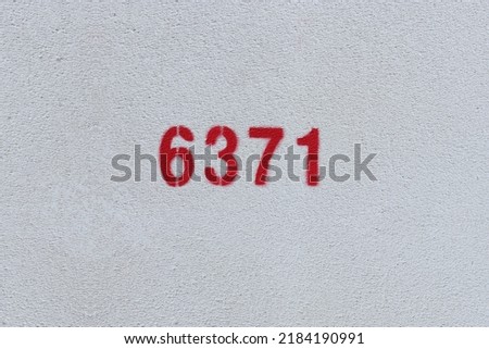 Red Number 6371 on the white wall. Spray paint.
