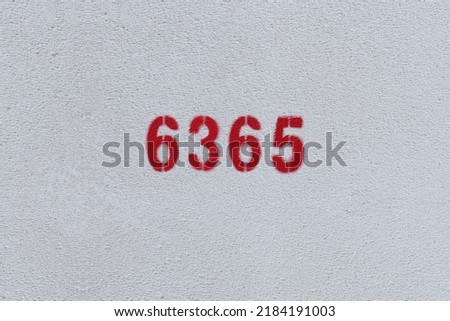 Red Number 6365 on the white wall. Spray paint.
