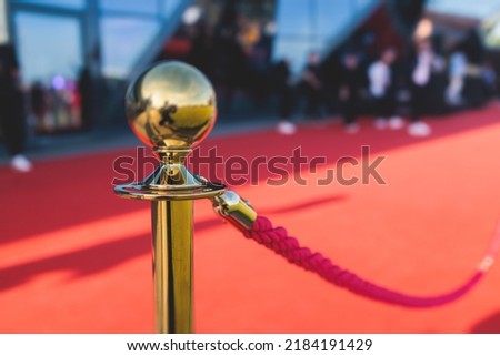 Red carpet with the ropes and golden barriers on a luxury party entrance, cinema premiere film festival event gala ceremony, wealthy rich guests ariving, outdoor decoration elements, summer sunny day
 Royalty-Free Stock Photo #2184191429