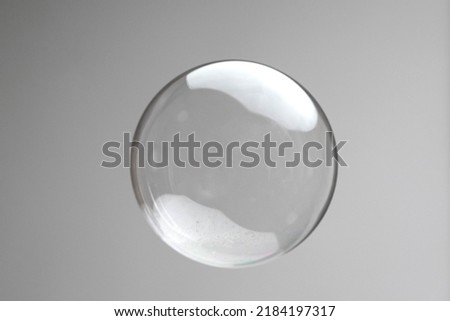 Flying soap bubbles on grey background. Abstract soap bubbles with reflections. Soap bubbles in motion background. Royalty-Free Stock Photo #2184197317