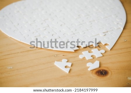 White part of jigsaw puzzle pieces on wooden table background. concepts of problem solving, business success, teamwork, Team playing jigsaw game incomplete, Texture photo with copy space for text