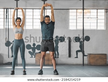 Fitness, active and healthy couple stretching, exercising or training together inside gym. Two young fit trainer doing a full body workout exercise or warmup routine in the day time with copy space Royalty-Free Stock Photo #2184214219