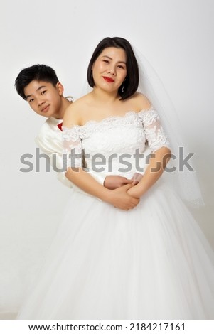 Asian son taking wedding photo with mother