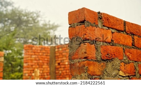 Brick wall under construction on nature background. Red Brick Wall With Diminishing Perspective. Fragment of brown brick wall with a shallow depth of field. Angled View Looking Down a Brick Alleyway.
