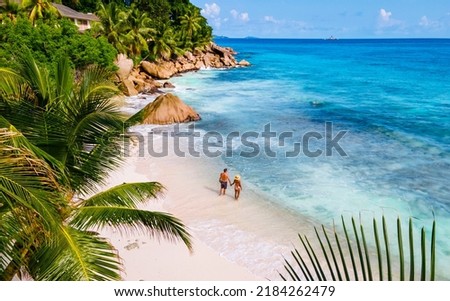 Anse Patates, La Digue Seychelles, a young couple of men and women on a tropical beach during a luxury vacation in Seychelles. Tropical beach Anse Patates, La Digue Seychelles Royalty-Free Stock Photo #2184262479