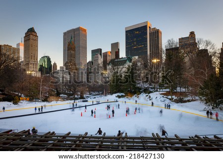 Winter scene in Central Park: the Wollman Rink at sunset. Families enjoying ice skating in the evening light during New York's wintertime. Central Park's Wollman Rink, Manhattan, NYC.