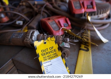 Safety workplaces yellow out of service tag attached on faulty damage  metal die grinder power tools  construction site Perth, Australia Royalty-Free Stock Photo #2184279269