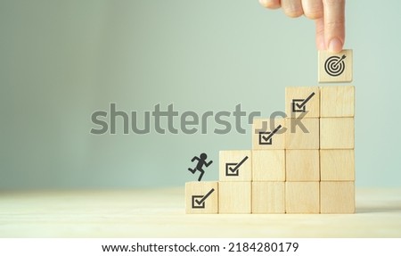 Corporate regulatory and compliance. Goals achievement and business success. Project and goals tracking. Task completion. Managing project timeline. Wooden cubes with target achievement icon. Royalty-Free Stock Photo #2184280179