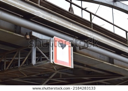 traffic sign for ships hanging under a railroad bridge