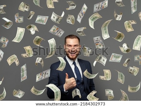 Successful confident excited businessman under American dollar money rain