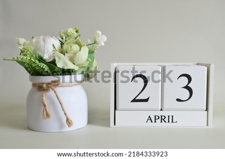 April 23, Cover natural background, white wooden Calendar cube with a pot flower on white background.