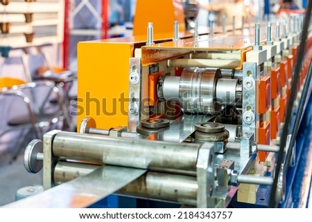 Roller feed unit of continuously high speed metal sheet strip c shape beam roll forming machine for manufacturing process in industrial Royalty-Free Stock Photo #2184343757