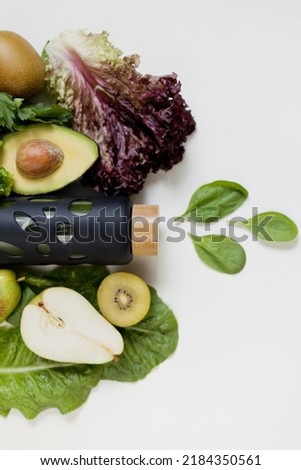 Bottle with green smoothie and various fruits and salad lettuce on a white background. Heathy food concept Royalty-Free Stock Photo #2184350561
