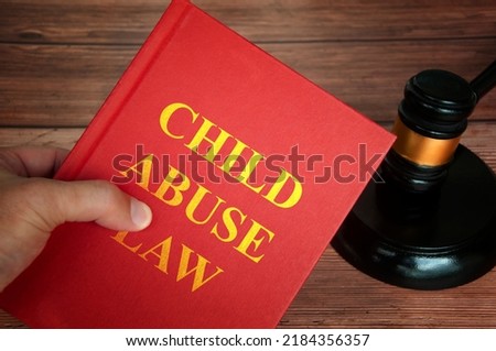 Child abuse law text on law book with judge gavel on wooden desk background. Law concept