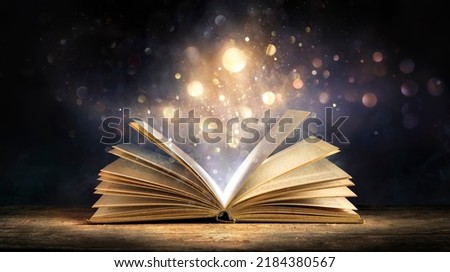 Magic Book With Open Antique Pages And Abstract Bokeh Lights Glowing In Dark Background - Literature And Education Concept Royalty-Free Stock Photo #2184380567