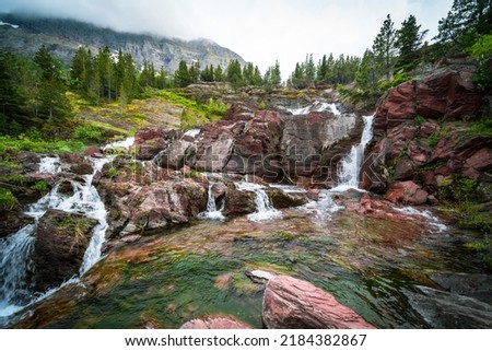 RedRock Falls waterfall in Glacier National Park along the Swiftcurrent Pass trail Royalty-Free Stock Photo #2184382867