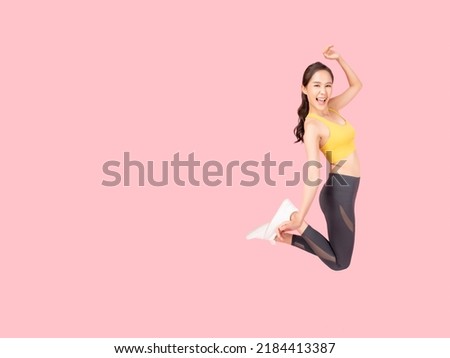 Full length body size of Cheerful woman jumping to the air wearing sportswear with excited face Isolated on pink background and copy space Health care Healthy Lifestyle Exercise and Workout concept