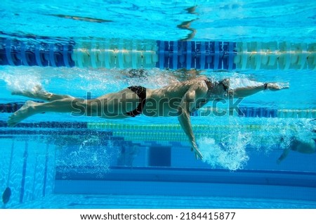 Underwater shooting of a swimmer in motion in a swimming pool                                Royalty-Free Stock Photo #2184415877