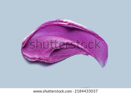 Lipstick abstract strokes smudge  background texture pinky-purple colored isolated on blue