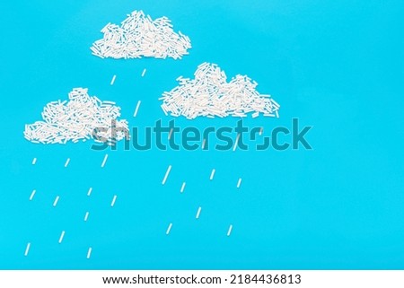 sprinkles on blue background in form of clouds and rain, concept of children creativity