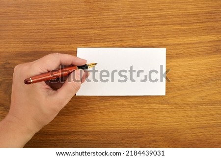 Woman writing by left hand. Left hander day concept. Royalty-Free Stock Photo #2184439031