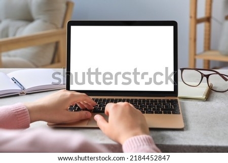 Woman working on laptop at white table, closeup. Mockup for design