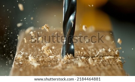 Freeze motion of a drill bit drilling into wood, macro shot Royalty-Free Stock Photo #2184464881