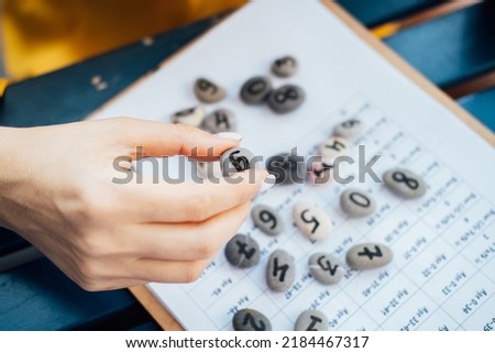 Woman numerologist hand with pebble stone with number nine 9. Royalty-Free Stock Photo #2184467317