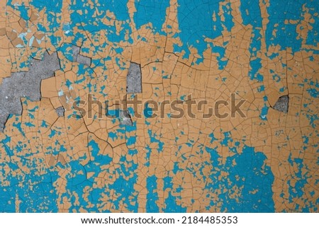 Peeling paint on the wall. Old concrete wall with cracked flaking paint. Weathered rough painted surface with patterns of cracks and peeling. High resolution texture for background and design. Closeup Royalty-Free Stock Photo #2184485353