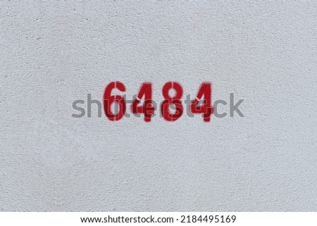 Red Number 6484 on the white wall. Spray paint.
