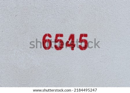 Red Number 6545 on the white wall. Spray paint.
