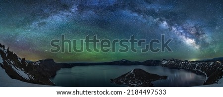 A colorful Milky Way panorama reflects in Crater Lake, captured on the Summer Solstice in Crater Lake National Park, Oregon.